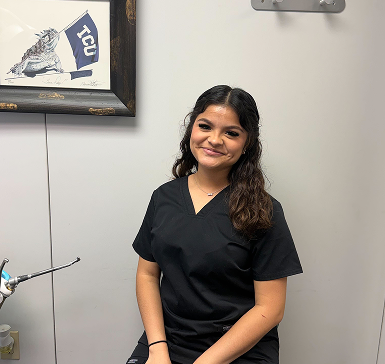 a photo of Adrianna (staff) smiling in black scrubs.