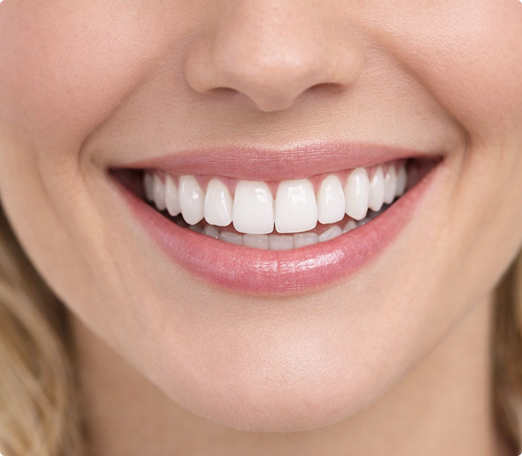 Close-up of a person smiling, showing bright white teeth and pink lips. The image conveys a sense of happiness and well-being.